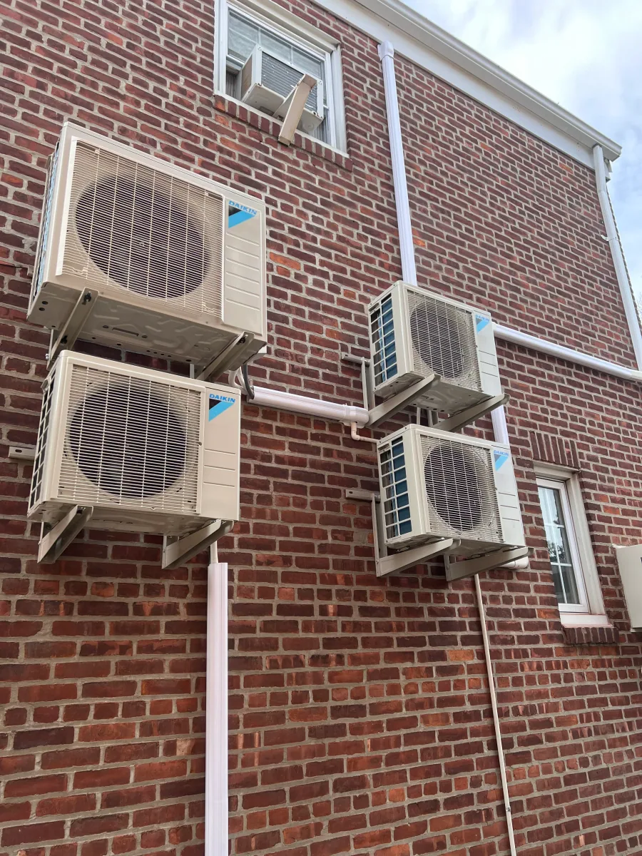 Outdoor HVAC equipment positioned along a brick building