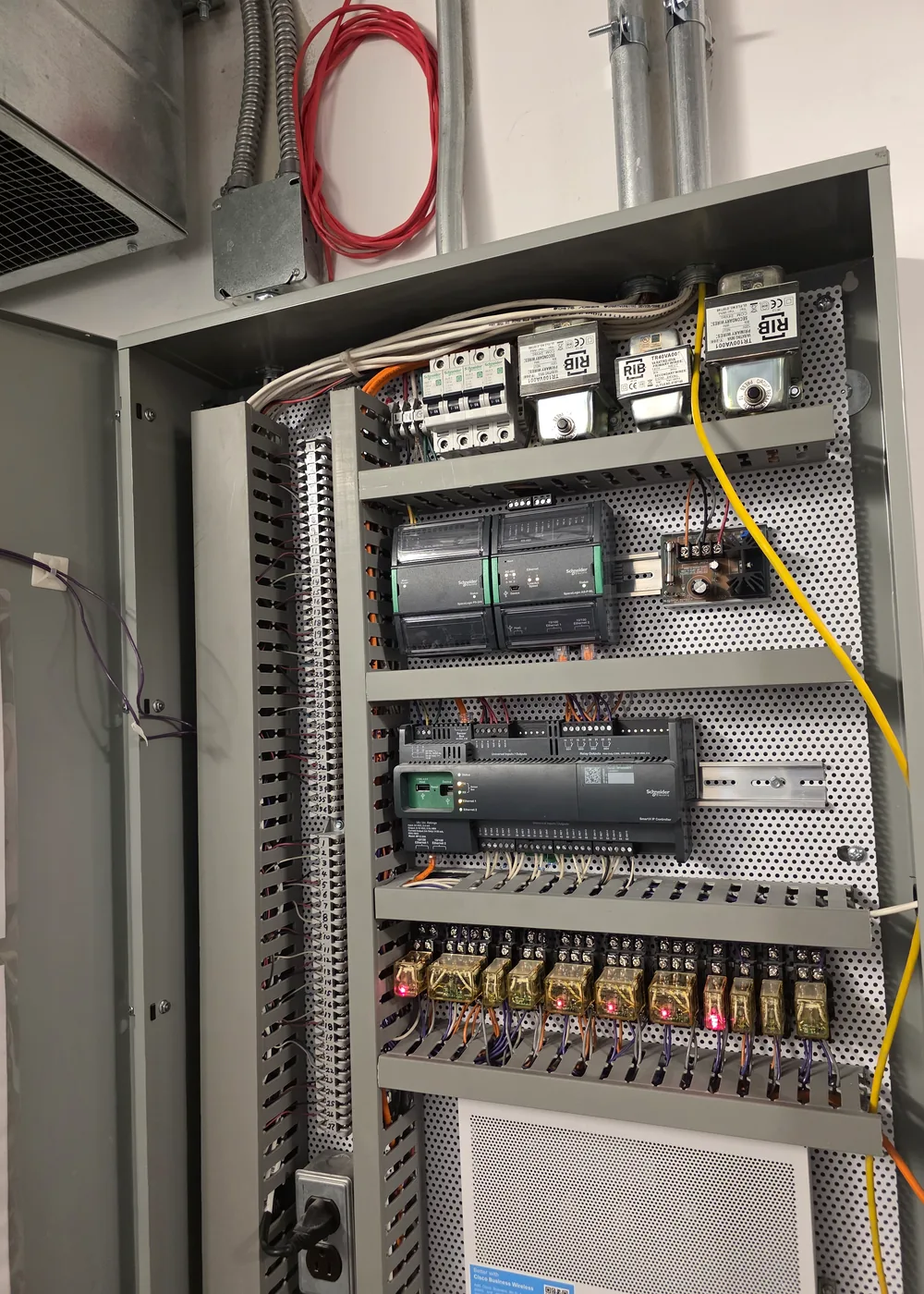 Open mechanical controls cabinet with organized breakers, relays, and control wiring