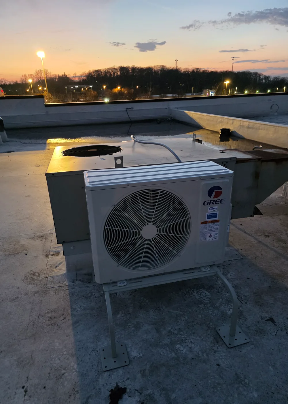 Exterior HVAC condenser on a commercial rooftop at sunset